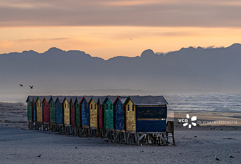 南非开普敦穆伊曾贝赫海滩色彩缤纷的海滩小屋上的绚丽日出图片素材