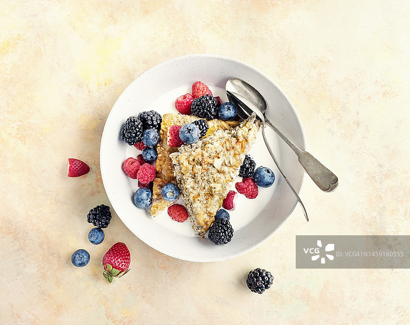 黄色背景碗里的燕麦棒、牛奶和浆果图片素材