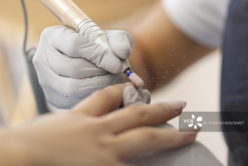 美甲师使用电动车床去除指甲上的丙烯酸图片素材