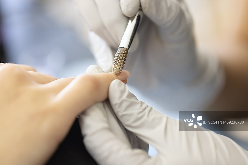 美甲师在指甲上涂抹丙烯酸图片素材