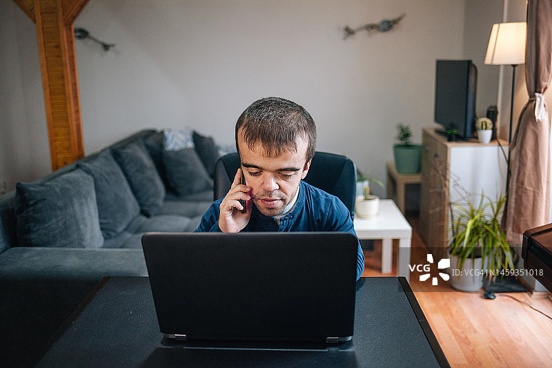 在家工作的患有侏儒症的年轻男人图片素材
