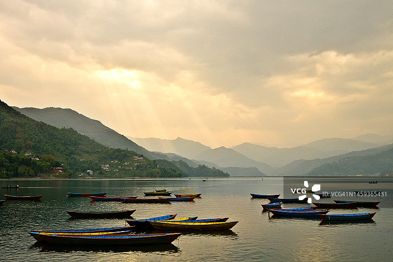 尼泊尔博克拉费瓦湖日落时分的船只图片素材
