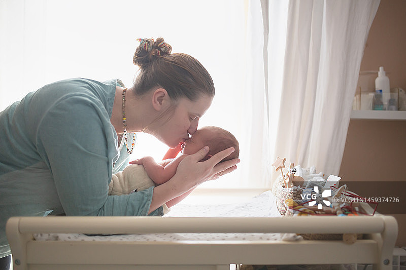母爱与新生儿护理：卧室里一个月大的宝宝和妈妈图片素材