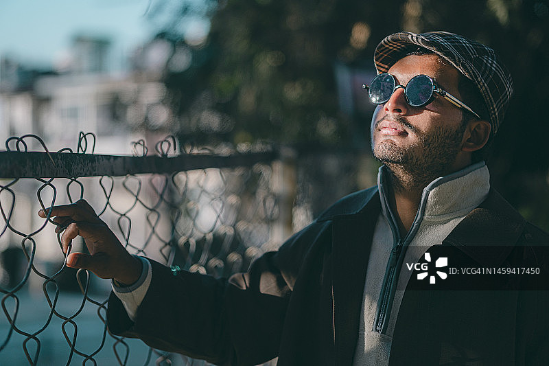 站在户外的时尚青年，看向远方图片素材