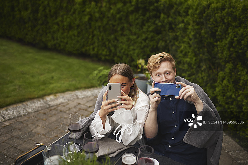 微笑的朋友们用手机拍照图片素材