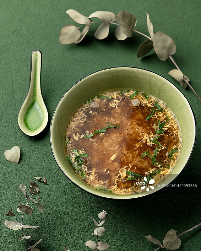 亚洲汤。绿色背景餐盘中的一份菜肴。亚洲美食。上菜。俯视图。图片素材
