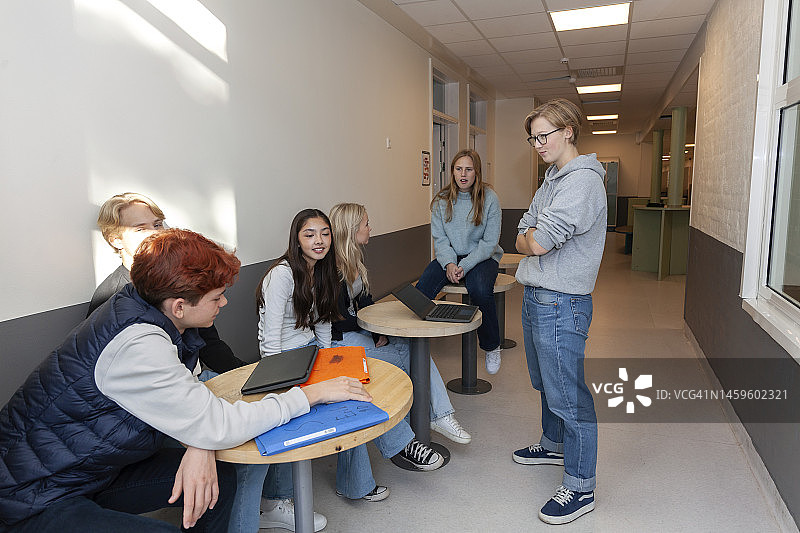 青少年坐在学校走廊里聊天图片素材