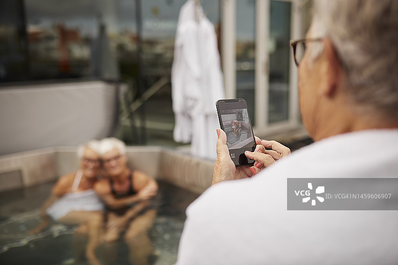 老年妇女用手机拍照图片素材