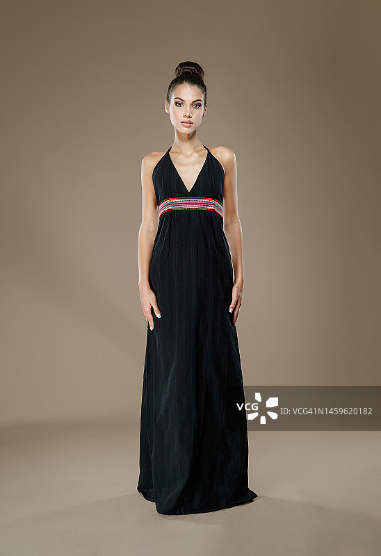 年轻棕发女子穿无袖长裙看镜头图片素材