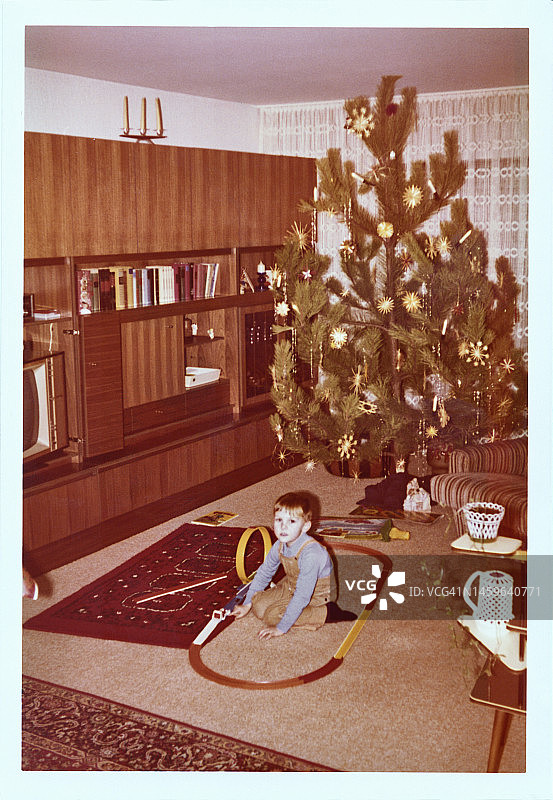 坐在圣诞树前的男孩图片素材