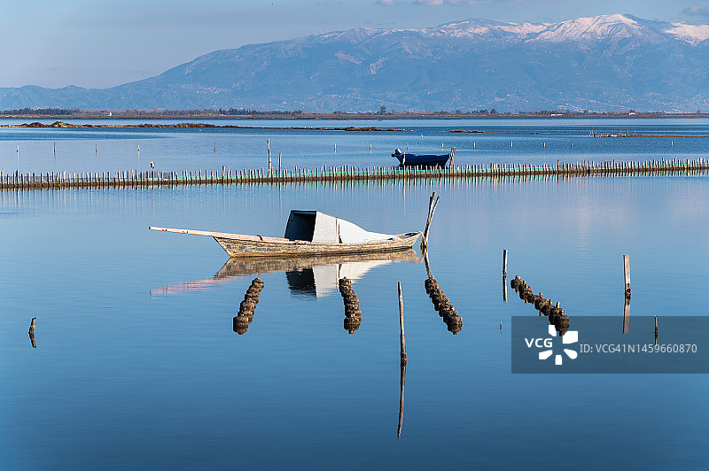 平静湖面上的旧渔船图片素材