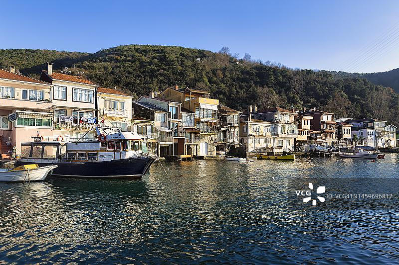 土耳其伊斯坦布尔阿纳多卢卡瓦伊，博斯普鲁斯海峡岸边的房屋和船只图片素材