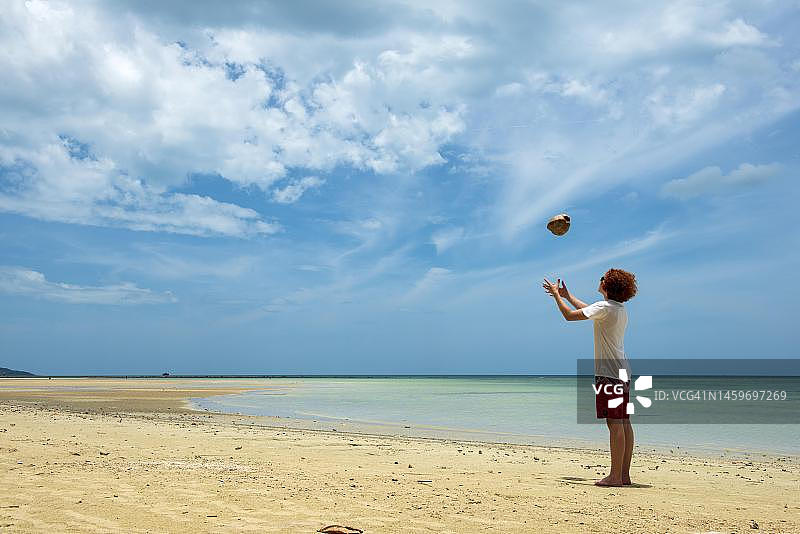 泰国苏梅岛邦考海滩，在海滩上抛椰子的年轻人图片素材