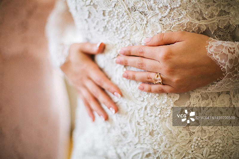 身穿蕾丝连衣裙，手上戴着结婚戒指的新娘图片素材
