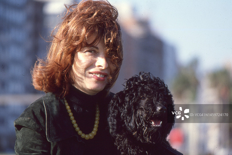 1979年乌拉圭蒙得维的亚一位美丽女人和她的黑狗的复古特写照片图片素材