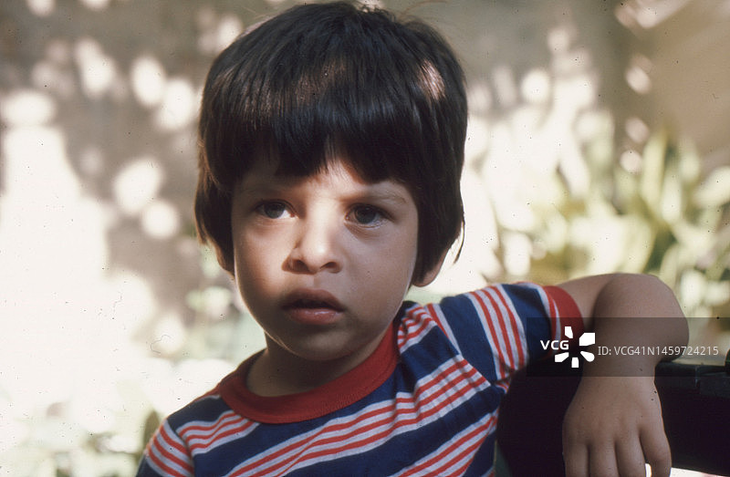 1977年意大利科莱帕尔多小镇：3岁男孩的复古特写照片，面部被阴影遮挡图片素材