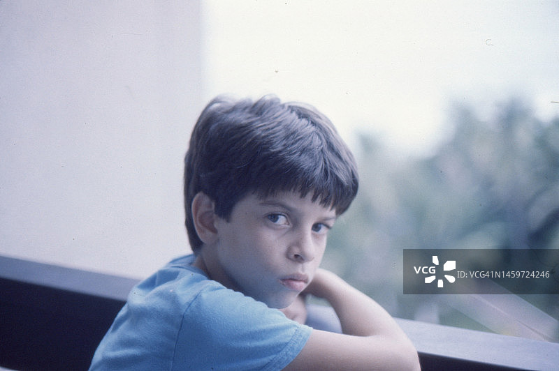 1981年伯利兹伯利兹市阳台上的一个年轻男孩的复古照片图片素材