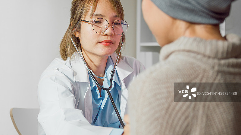 年轻亚洲女医生用听诊器检查病人特写，医疗保健图片素材