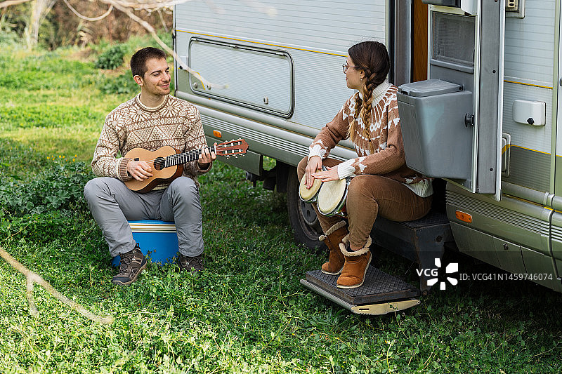 情侣在旅行车外演奏音乐图片素材