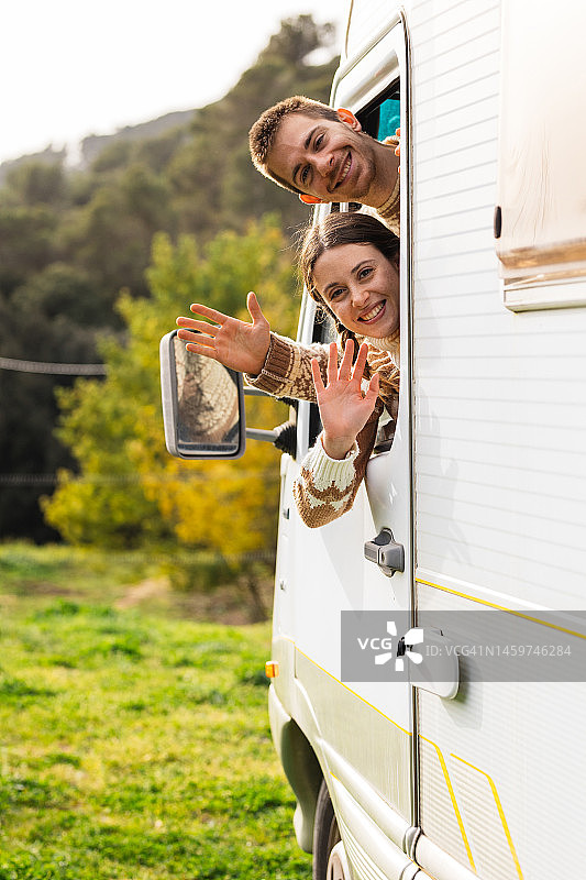 情侣在露营车内挥手图片素材