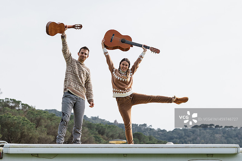 幸福情侣在房车顶上弹吉他图片素材