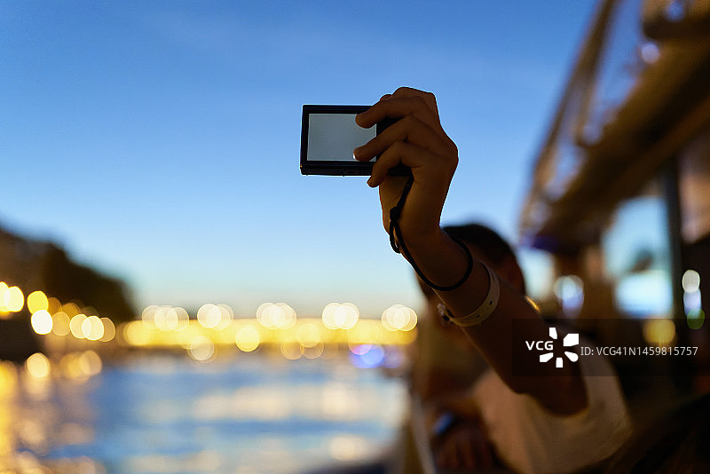 女孩在巴黎塞纳河的船上用相机自拍图片素材