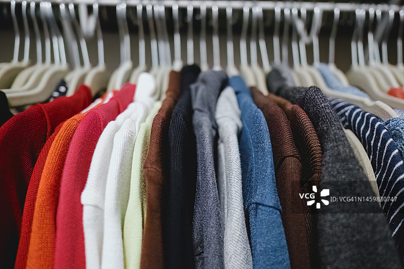 衣柜中悬挂的彩色针织上衣图片素材