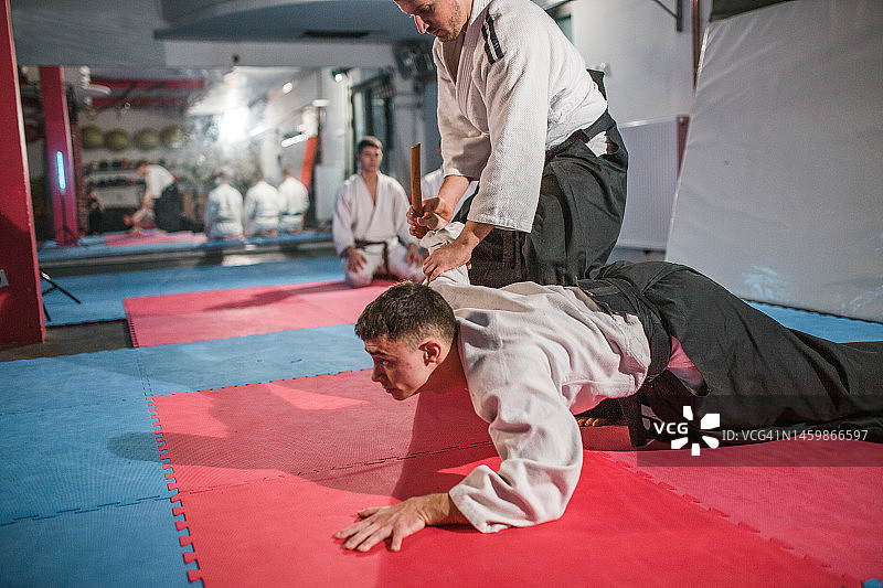 两位武士在健身房向年轻战士展示合气道技巧图片素材