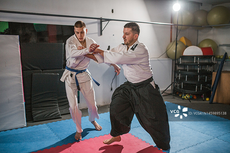 自信的年轻斗士与合气道大师搏斗图片素材