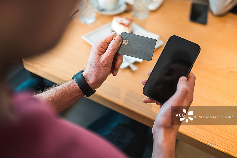 在咖啡馆使用智能手机的白人男子图片素材