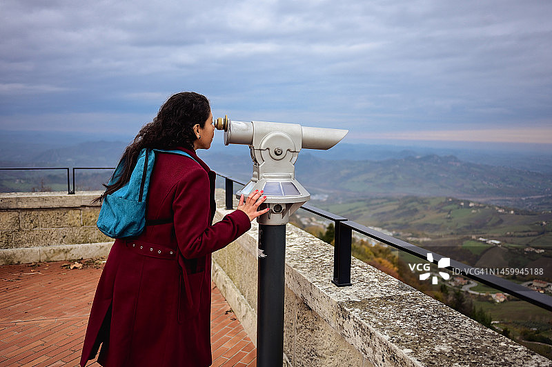 站在山上用望远镜观察的美国女人侧视图图片素材