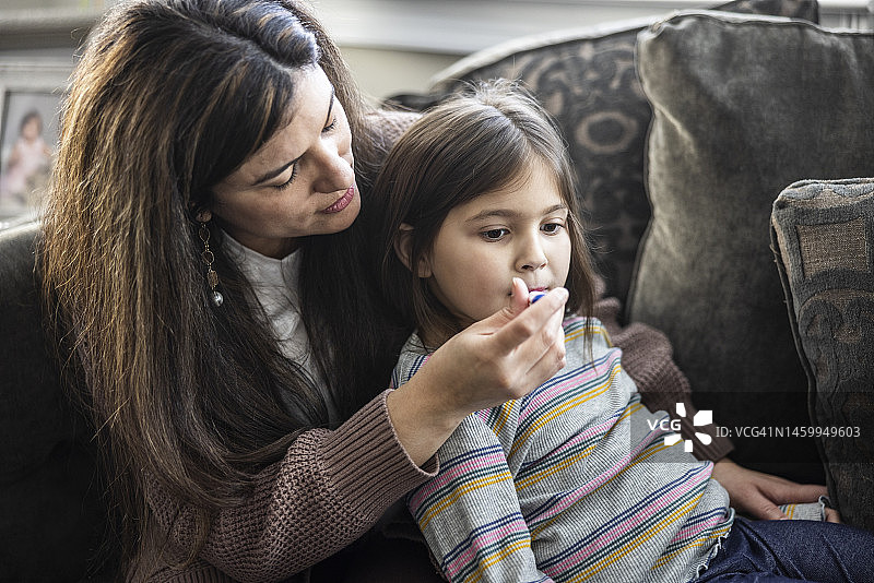 母亲在家给女儿量体温图片素材