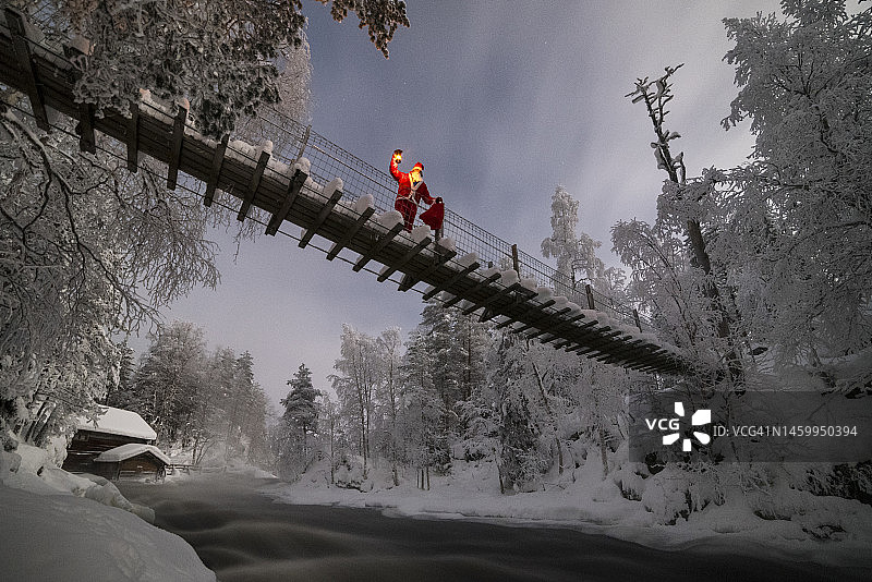 寒冷冬夜里在桥上提着灯笼的圣诞老人图片素材