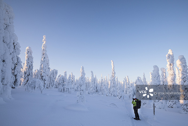 摄影师在芬兰的雪林中拍摄照片图片素材