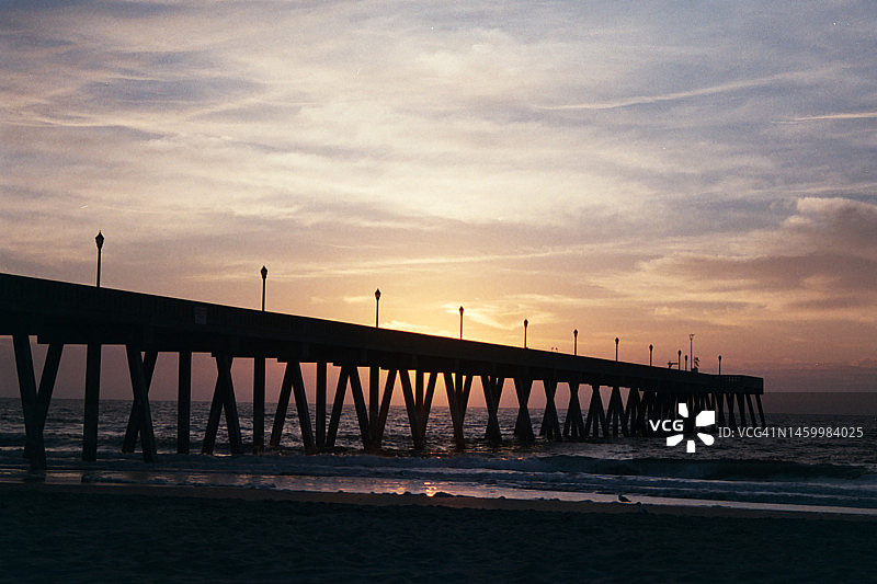 太阳升起在海滩码头上图片素材