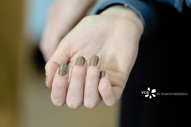 白人女人的手轻微合拢，可见其闪亮的美甲图片素材