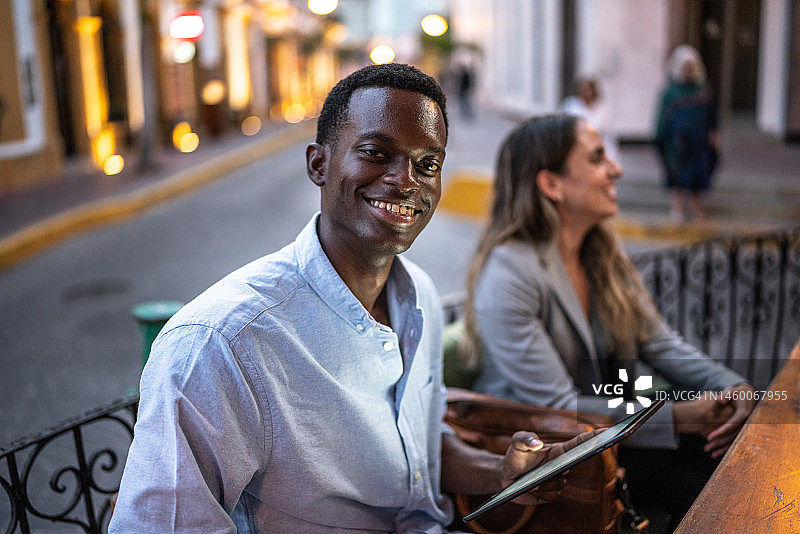 年轻男子在咖啡店会议中使用平板电脑的肖像图片素材