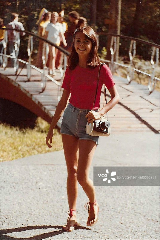 穿着短裤，携带相机的年轻女子图片素材