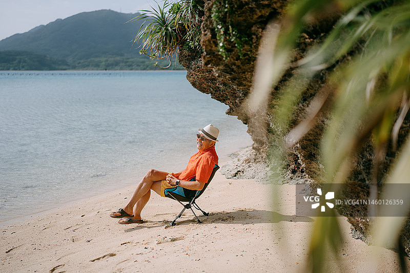 老年男子在热带海滩上放松图片素材