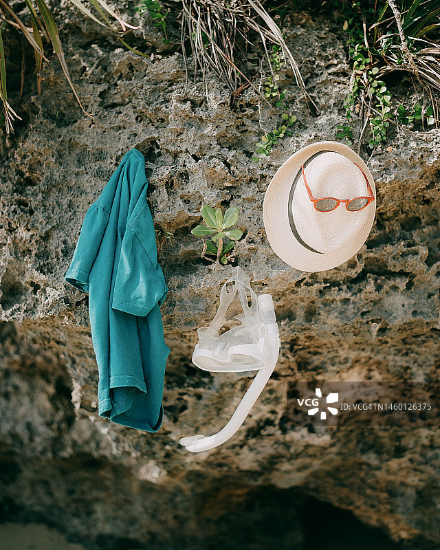 珊瑚礁上的浮潜面罩、草帽和T恤图片素材