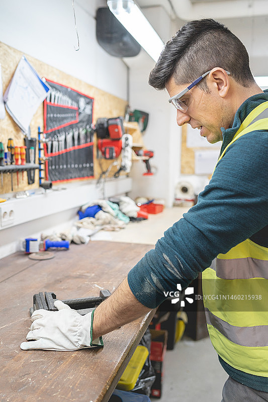 工人仔细观察零件图片素材