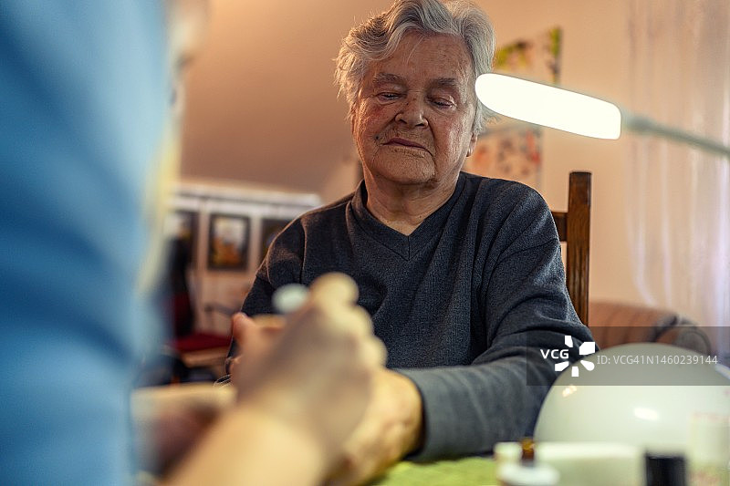 年长的女人享受志愿者的美甲服务图片素材