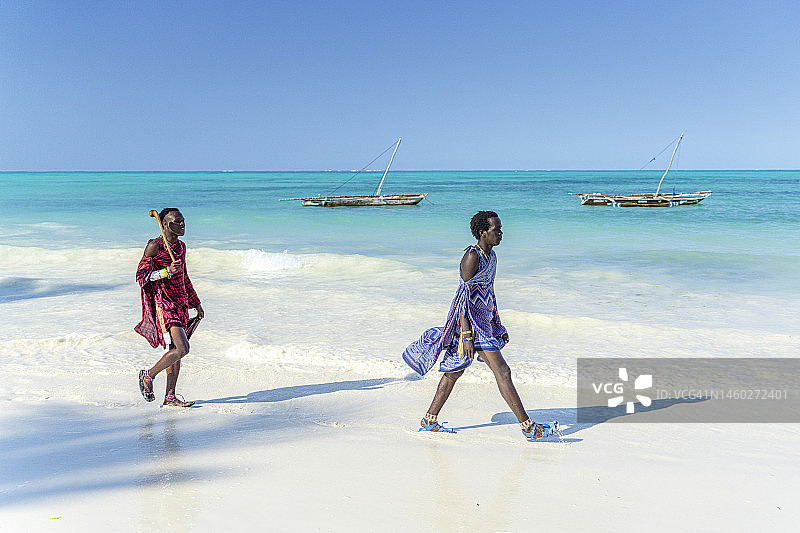 两位年轻的马赛男人走在田园诗般的海滩上，桑给巴尔图片素材