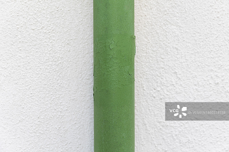 白色墙壁上的绿色金属管道特写图片素材