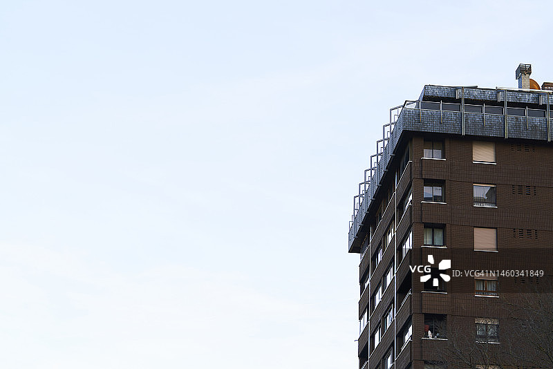 白天，带有阳台和玻璃窗的多层建筑外观图片素材