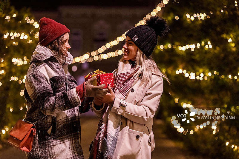 年轻女子给她的女朋友送圣诞礼物图片素材