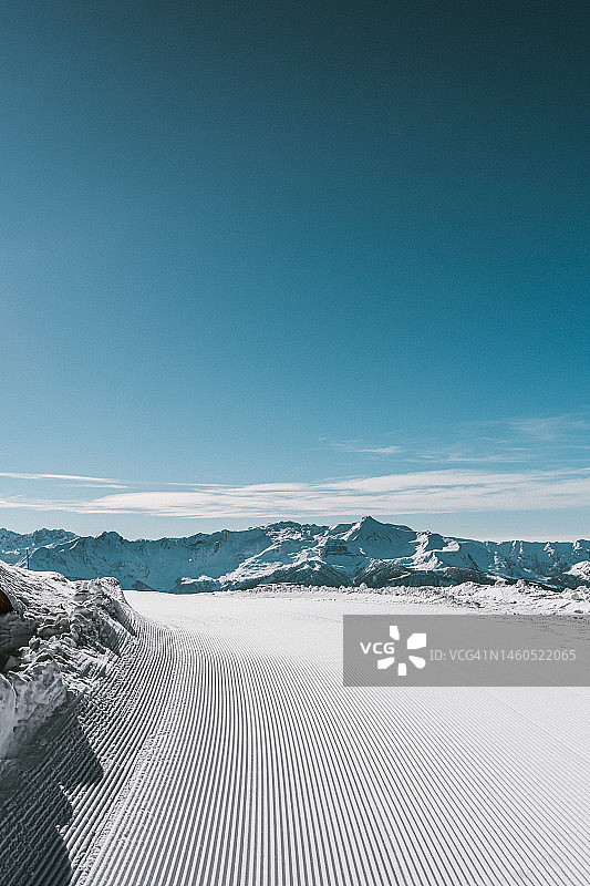 风景如画的滑雪坡，山上有新鲜的滑雪道，冬季背景图片素材