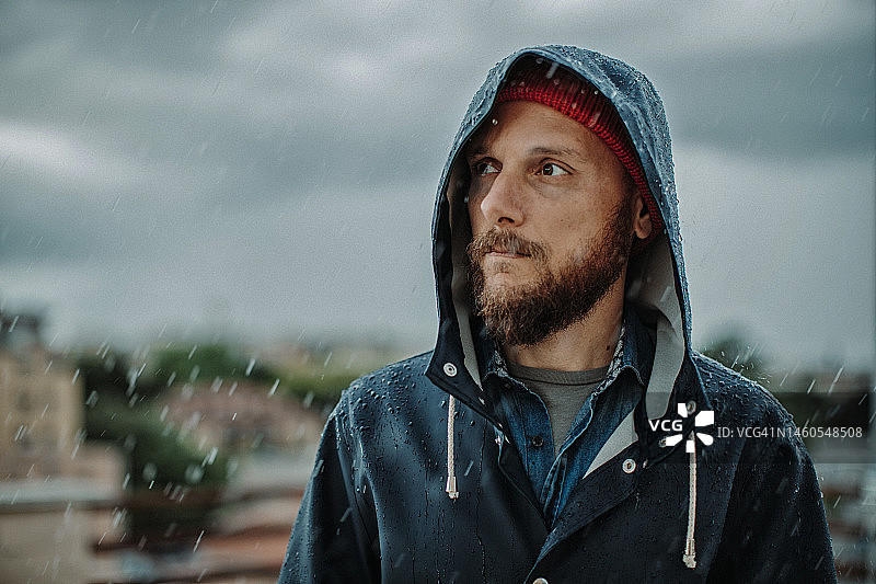 络腮胡男人肖像：在雨中穿着雨衣图片素材