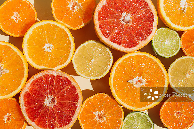 米色背景上的柠檬、橙子、葡萄柚、酸橙柑橘切片图案图片素材