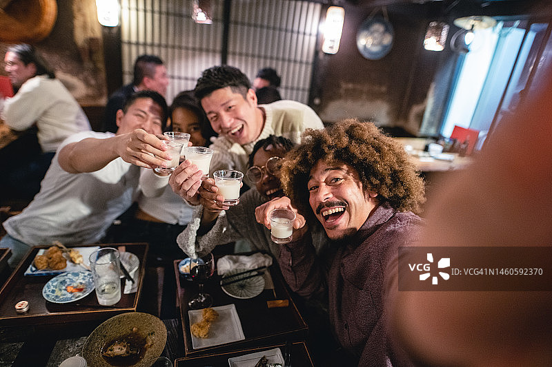 年轻同事在日本酒吧自拍并举杯图片素材